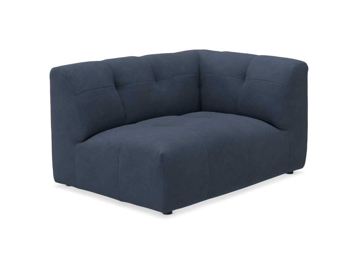 Mørkeblå hjørnemodul-sofa med blød polstring og afrundede former.