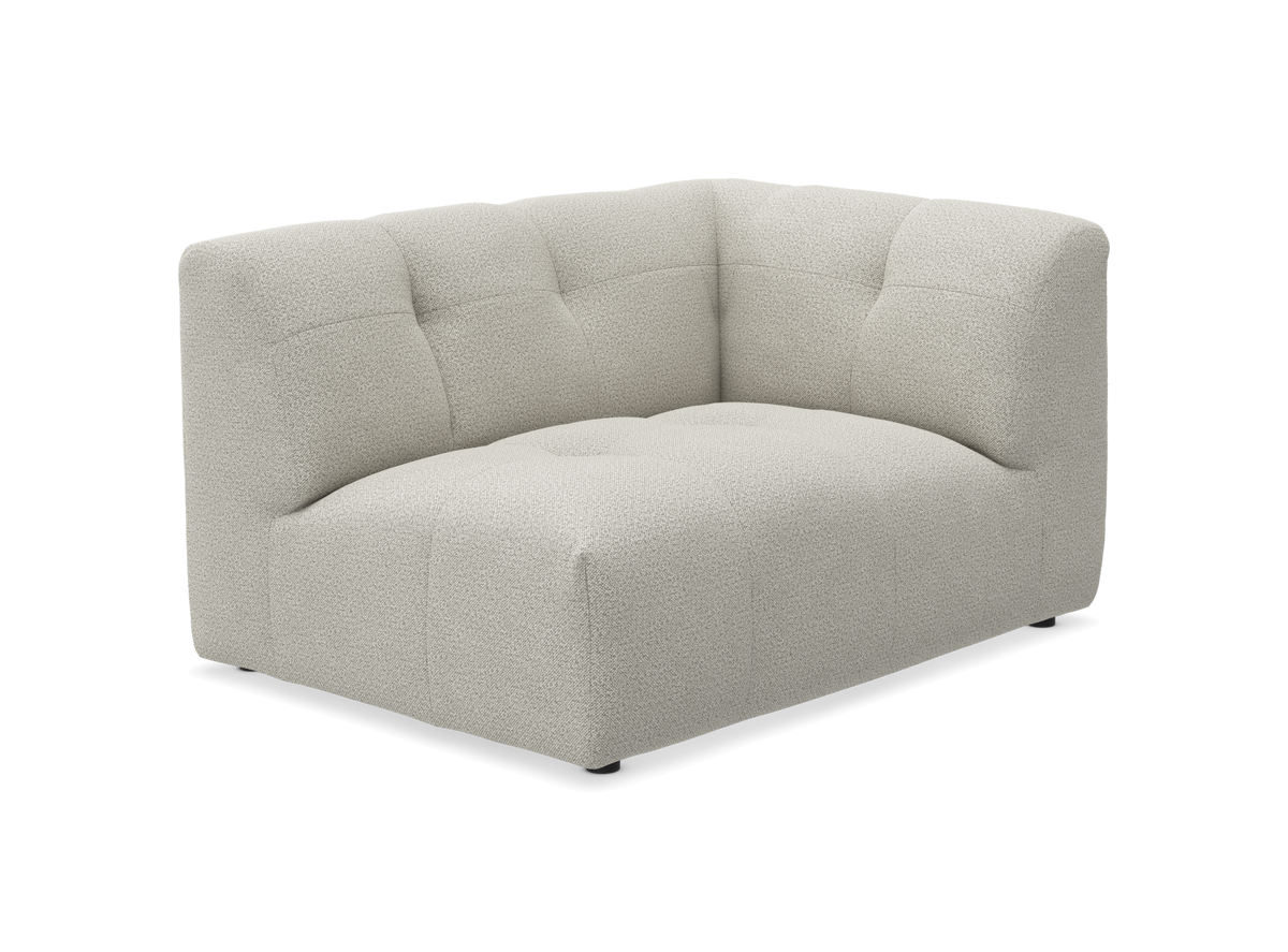 Lys beige hjørnemodul til sofa i bouclé, blød polstring med diskrete tuftninger.