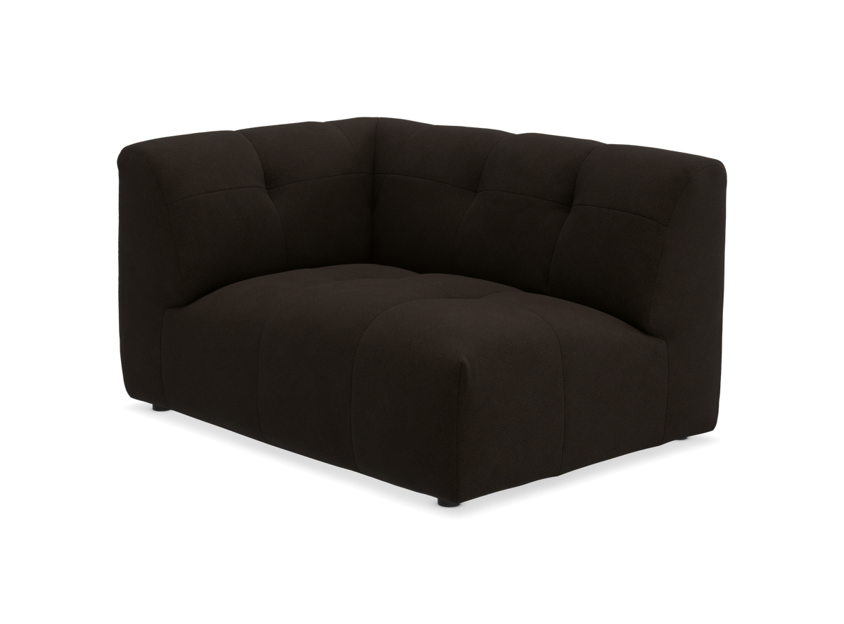 Mørkebrun hjørnemodul til sofa med blød, quiltet polstring, frilagt på sort baggrund.