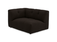 Mørkebrun hjørnemodul til sofa med blød, quiltet polstring, frilagt på sort baggrund.