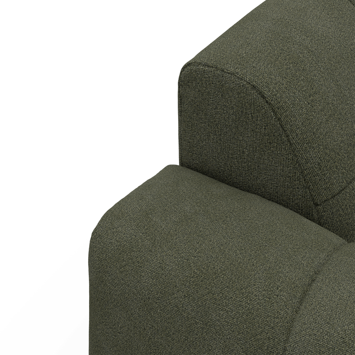 Nærbillede af grønt stofbetrukket sofa-armlæn og ryglæn mod hvid baggrund i studiemiljø.