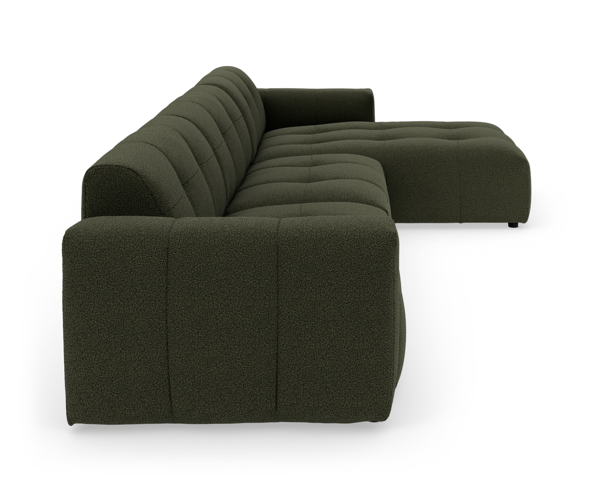 Modulsofa i mørkegrønt stof, L-formet med dybe kanalsyninger, set fra siden på hvid baggrund.