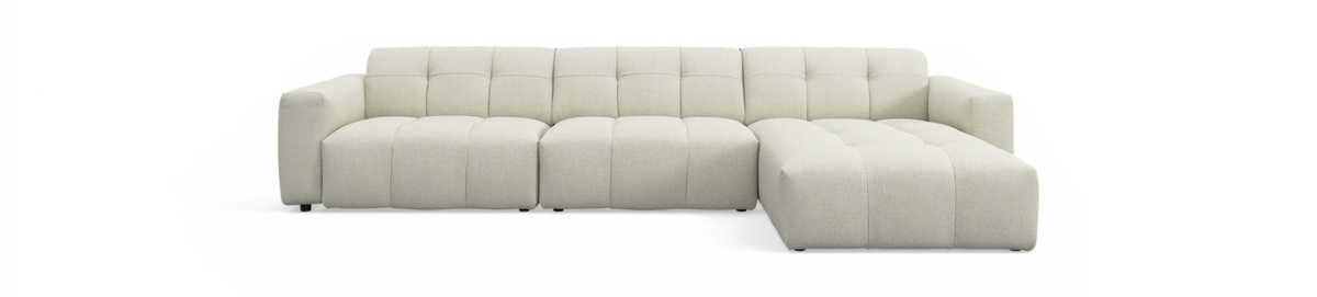 Lys beige modulsofa med højrevendt chaiselong, tuftet sæde og lav profil, fritlagt på sort baggrund.