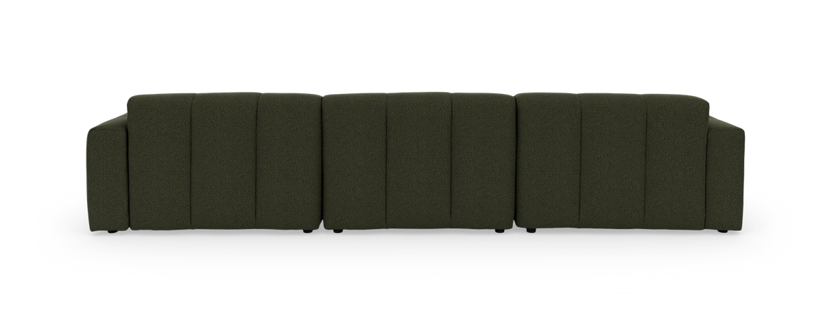 Grøn modulsofa med venstrevendt chaiselong, frilagt på sort baggrund.
