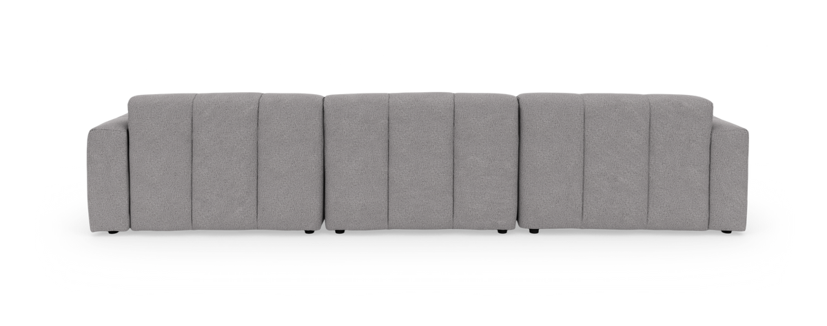 Lysegrå modulsofa med venstrevendt chaiselong i tuftet, blødt afrundet design, frilagt på sort baggrund.