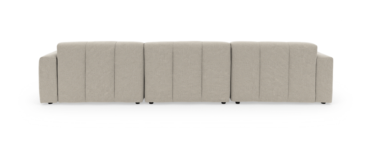 Lys beige modulsofa i L‑form med venstrevendt chaiselong og tuftede sædehynder, frilagt på hvid baggrund.