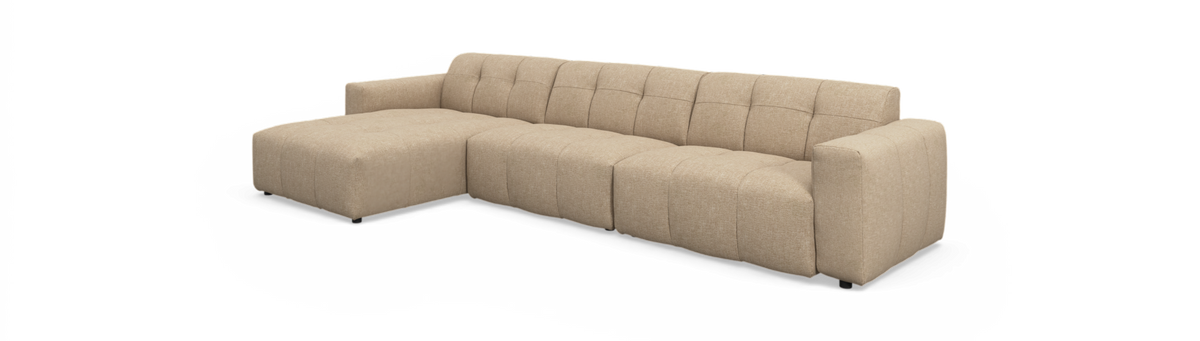 Beige modulsofa med venstre chaiselong, lav ryg og blokarmlæn, quiltede sømme; frilagt på hvid baggrund.