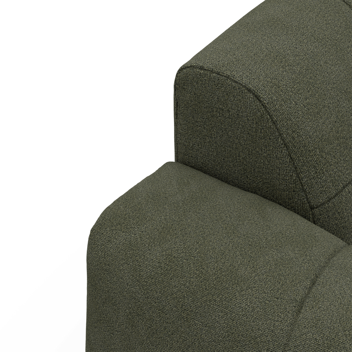 Nærbillede af grøn stofbetrukket sofa med arm- og ryglæn i studie.