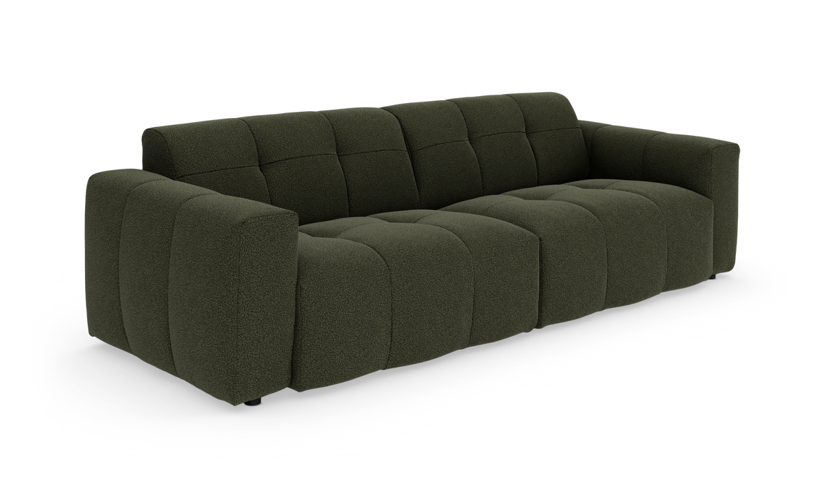 Mørkegrøn modulsofa med dybe, quiltede sæder, set skråt forfra mod hvid baggrund.