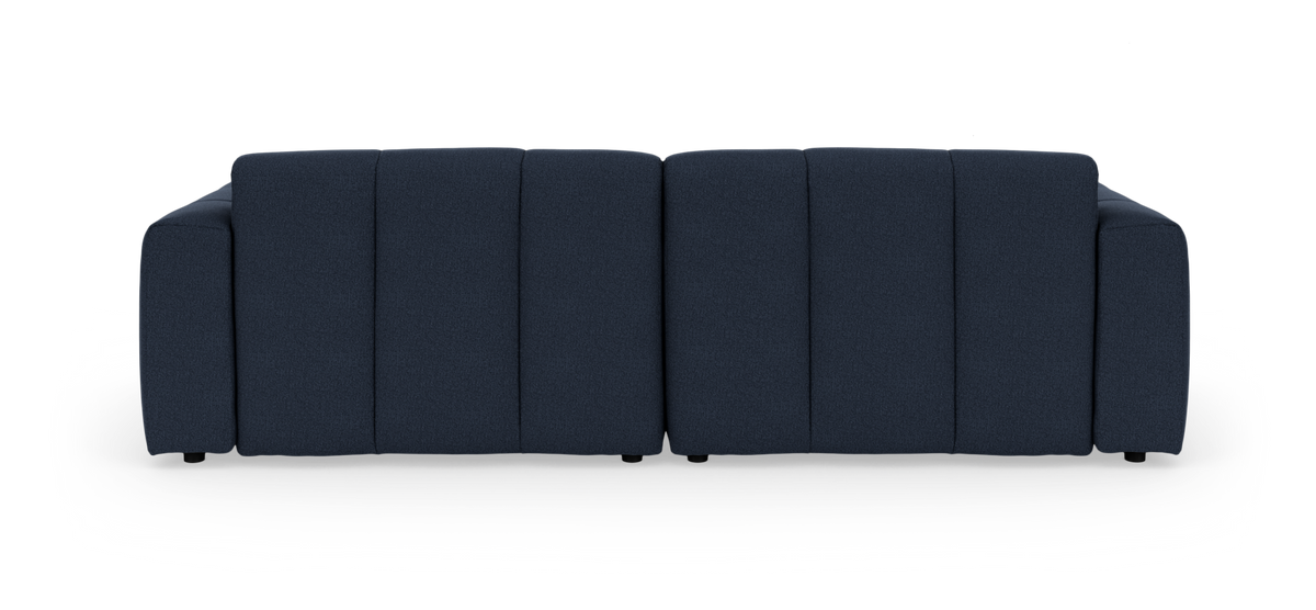 Mørkeblå, moderne modulsofa i stof set forfra mod sort baggrund.