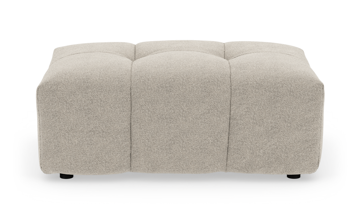 Beige, kvadratisk puf i stof med blød, tuftet top på hvid baggrund.