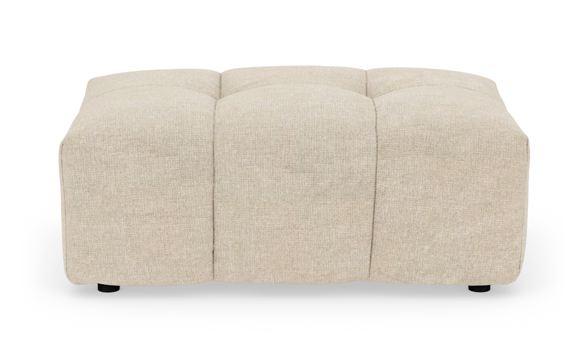 Beige, firkantet polstret puf/skammel med blød kviltning, set forfra på hvid baggrund.