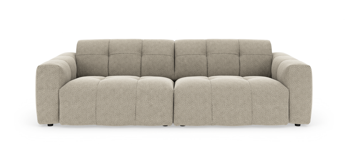 Beige modulsofa med brede, afrundede armlæn og let tuftede sædehynder, frilagt på hvid baggrund.