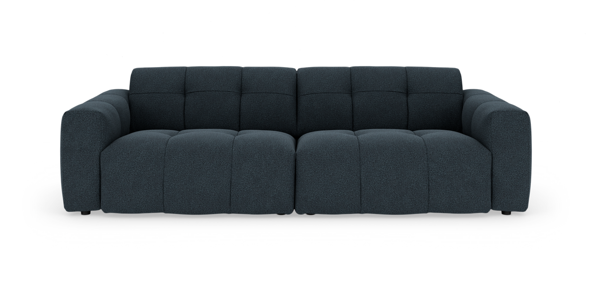 Mørkeblå modulsofa med brede, bløde puder set lige forfra på hvid baggrund.
