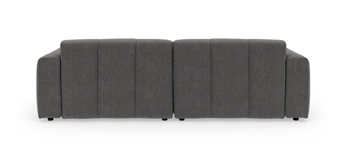 Mørkegrå modulsofa set lige bagfra mod hvid studiebaggrund.