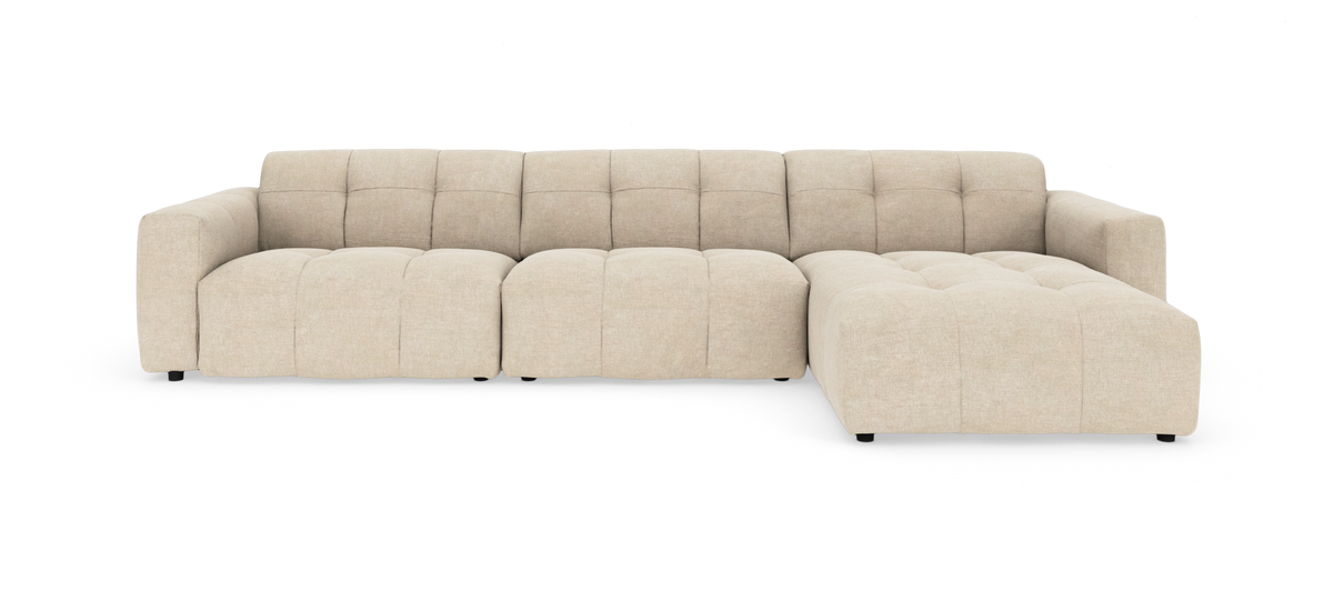 Beige modulsofa med højrevendt chaiselong og dyb, blød, tuftet polstring.
