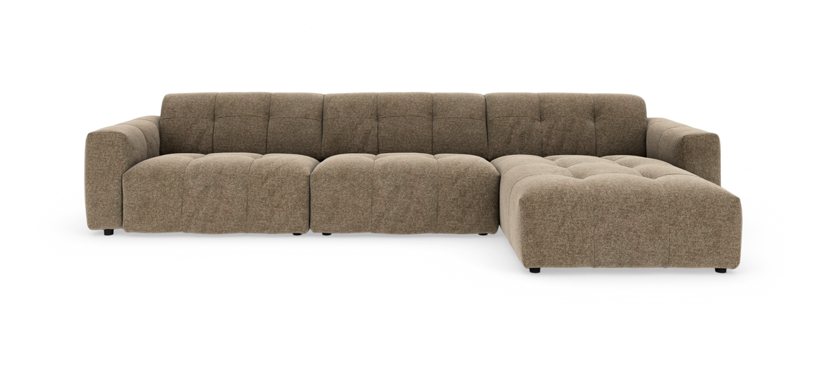 Modulsofa i brun‑beige stof med chaiselong til højre, bløde tuftede sædehynder og lav profil.