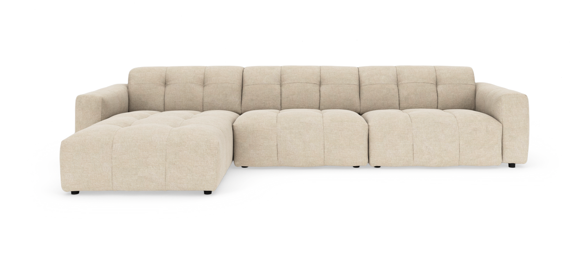 Beige modulsofa i stof med venstre chaiselong, lav profil og tuftede sædehynder.