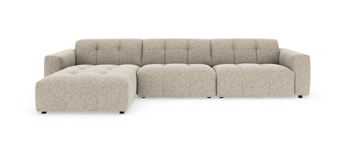 Beige modulsofa med venstrevendt chaiselong, bred siddeplads og dybe tuftede puder på hvid baggrund.