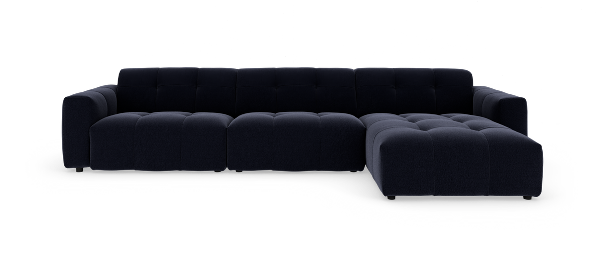 Mørkeblå modulsofa med chaiselong til højre, dybt sæde og quiltet polstring.