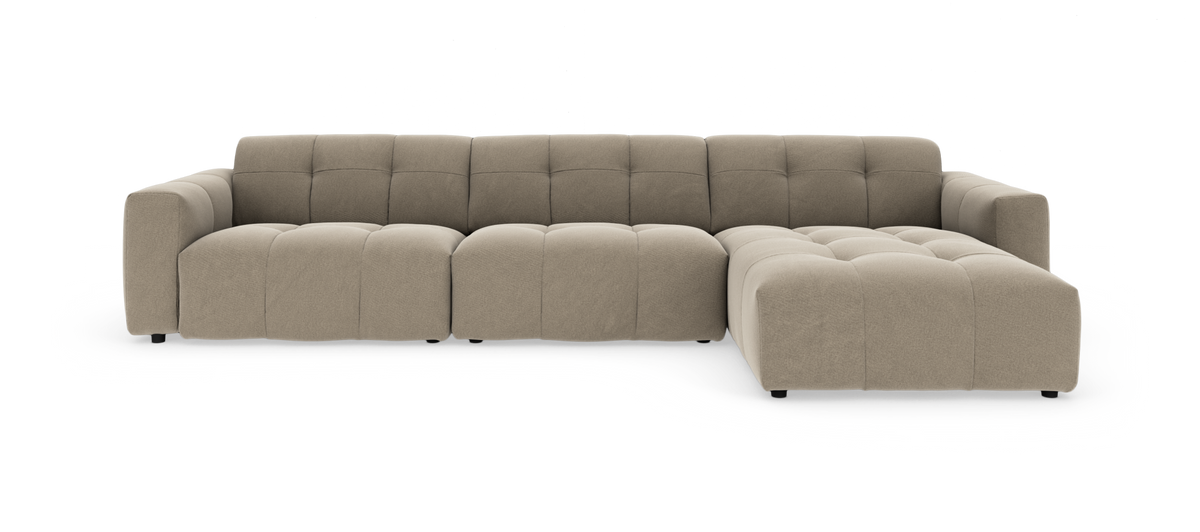 Beige modulsofa med chaiselong til højre, dybt sæde og blød, quiltet polstring.
