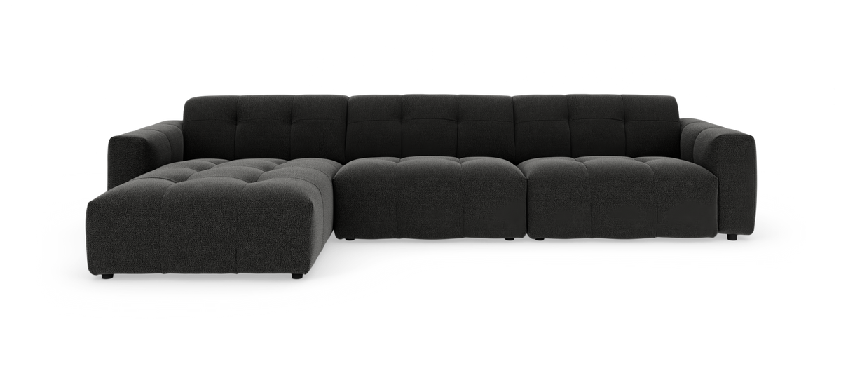 Mørkegrå modulsofa med chaiselong og tuftet sæde, frilagt på hvid baggrund.