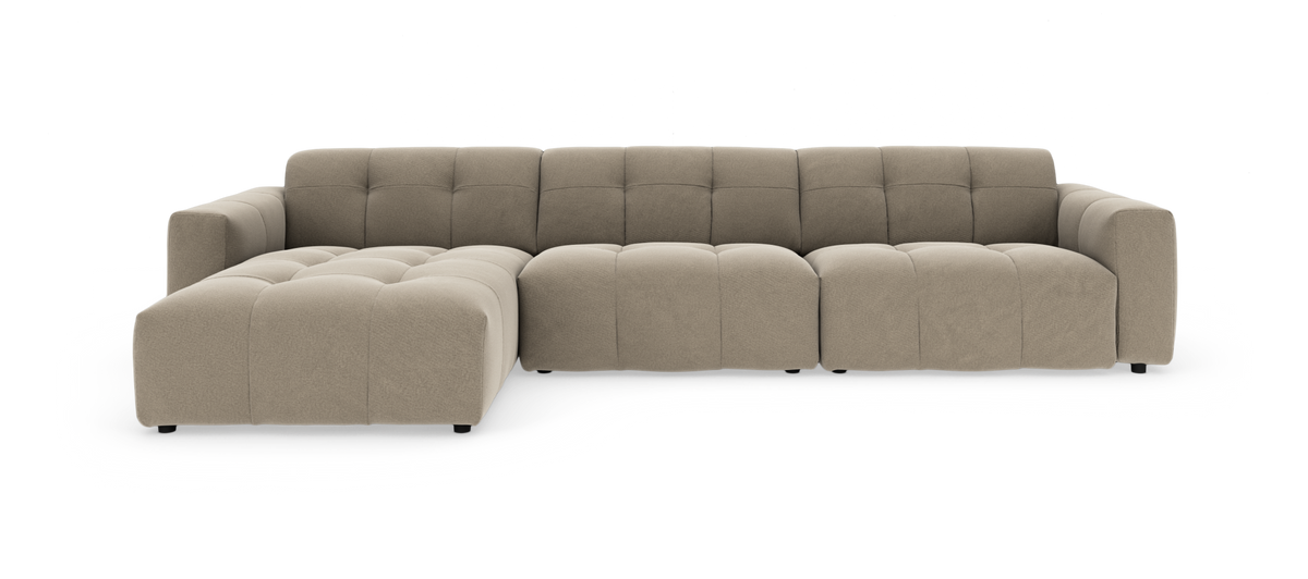 Beige modulsofa med chaiselong i frontvinkel på hvid studiobaggrund.