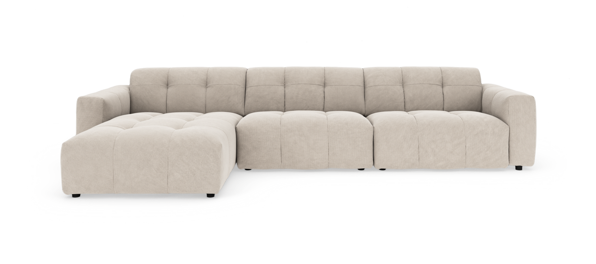 Stor beige modulsofa med venstre chaiselong, quiltede sæder og afrundede armlæn, fritlagt på hvid baggrund.