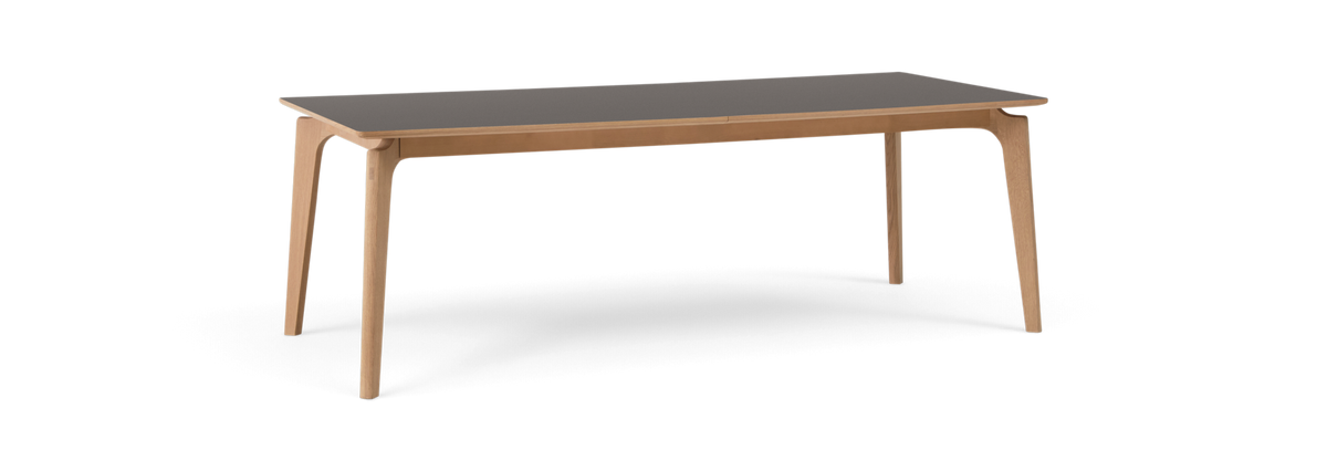 Rektangulært bord med sort bordplade og ben i lyst træ, moderne minimalistisk design.