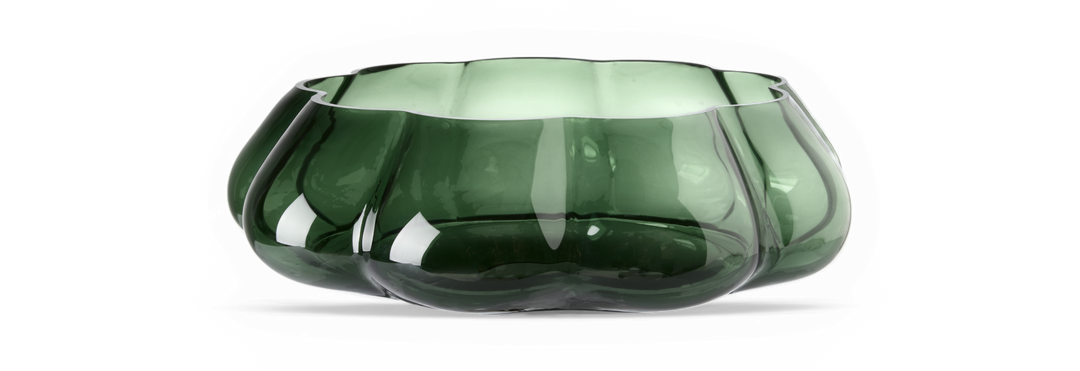 Mørkegrøn riflet glasskål med bølget kant på sort baggrund.