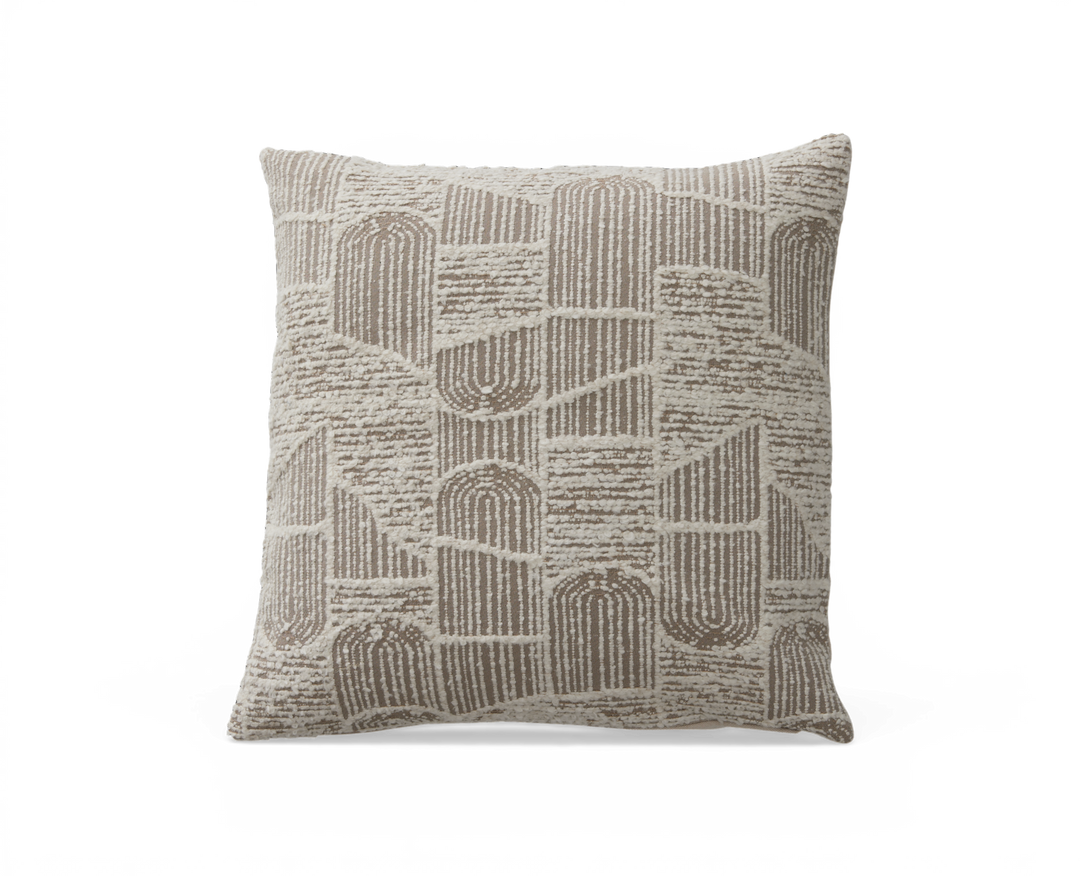 Beige og creme pyntepude med tuftet geometrisk buemønster, fotograferet forfra i studiemiljø.