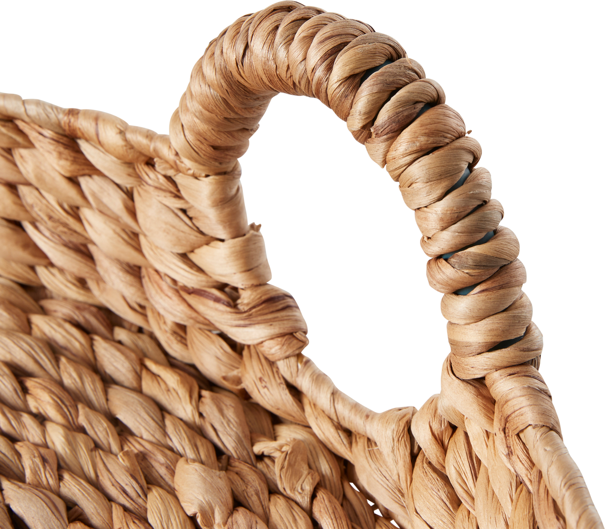 Nærbillede af håndtag på flettet kurv i naturfibre mod hvid baggrund.