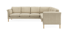 Beige L-formet hjørnesofa med træben, frontvisning frilagt på hvid baggrund.