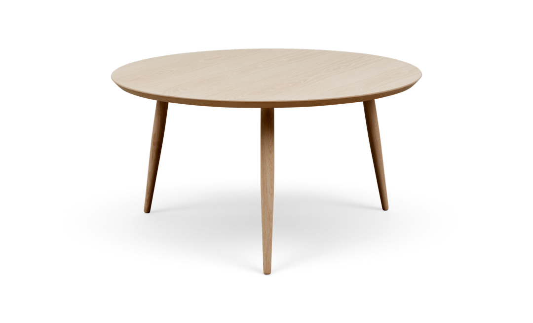 Rundt sofabord i lys eg med tre koniske ben, frilagt på hvid baggrund.