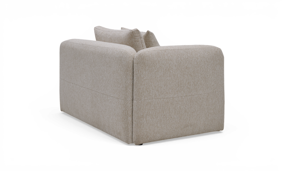 Beige modulsofa med afrundede hjørner og to rygpuder, set bagfra i studie.