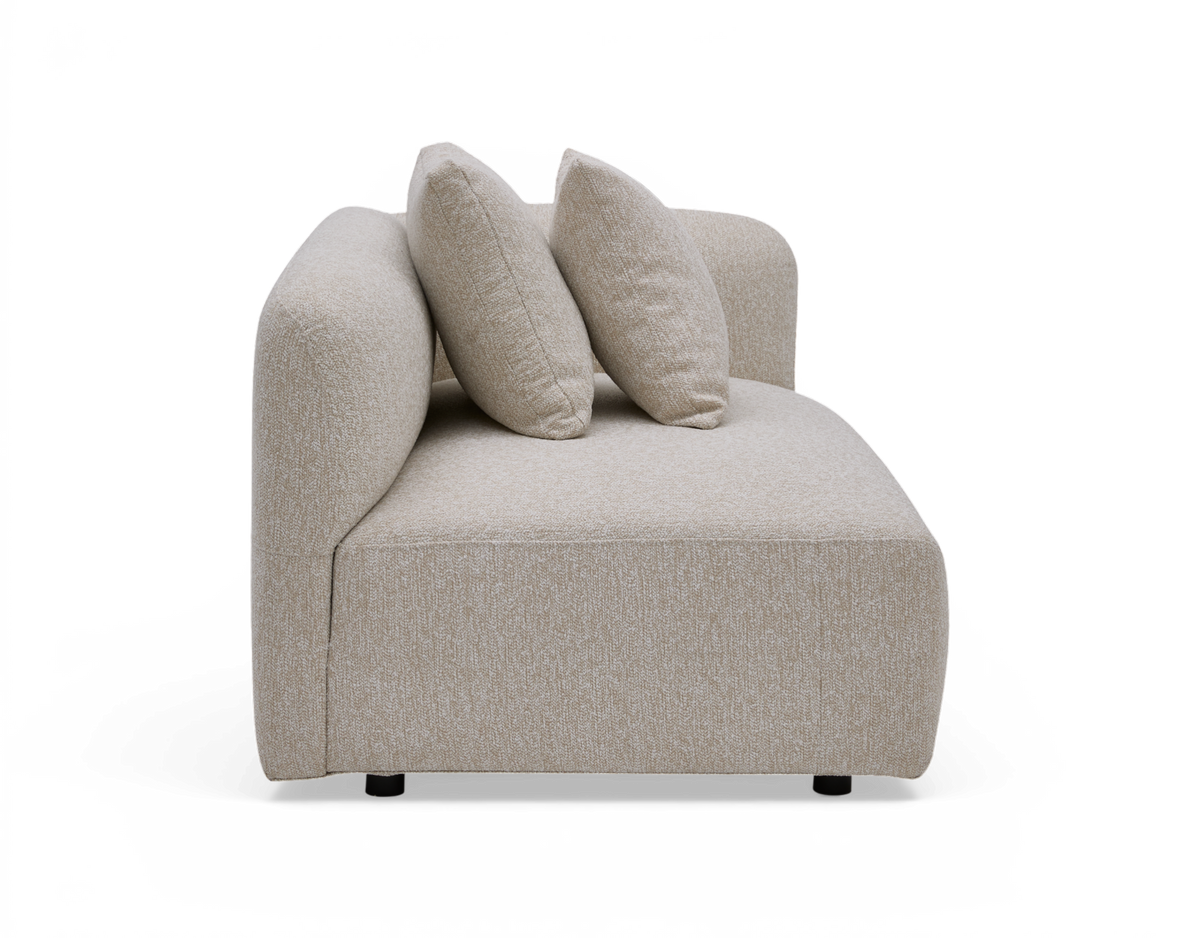 Beige modulsofa med venstre armlæn og to puder, sidevisning, frilagt på hvid baggrund.
