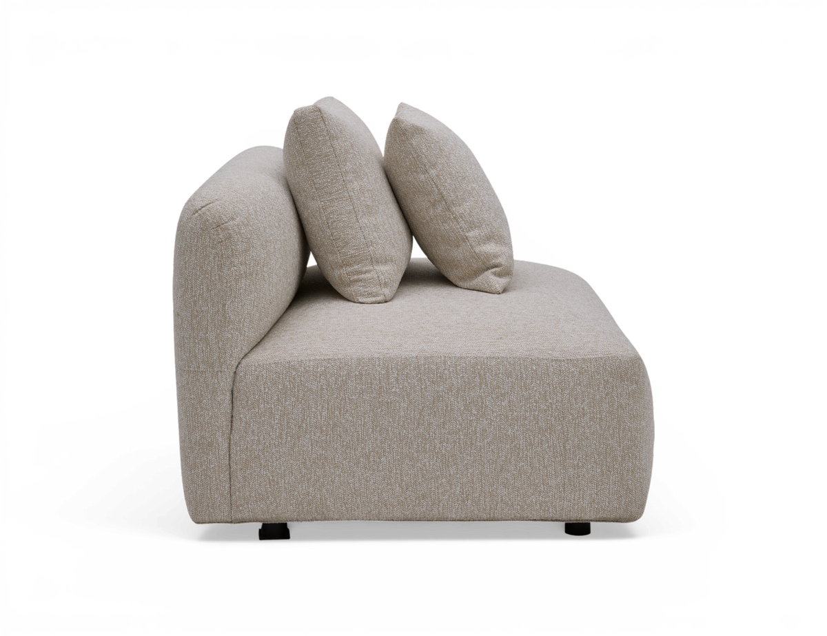 Beige modulsofa i stof med to ryghynder, set fra siden.
