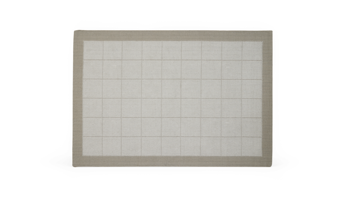 Lysegråt tæppe med diskret ternet mønster og beige/taupe kant hele vejen rundt.