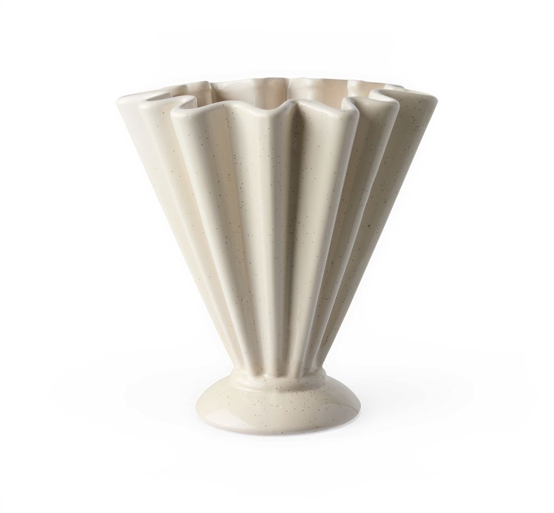 Cremefarvet riflet keramisk vase med piedestalfod, med stænk, fritstående på hvid baggrund.