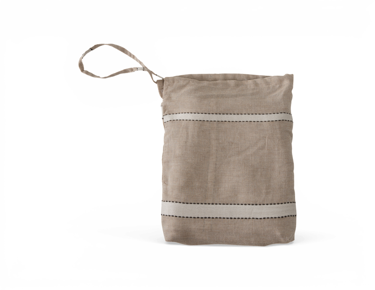 Beige linnedpose med håndrem og to horisontale hvide striber med sorte stikninger, fritlagt produktbillede.
