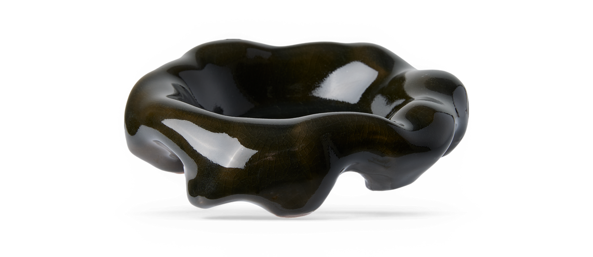 Blank mørkegrøn bølgeformet glasskål med organisk form.