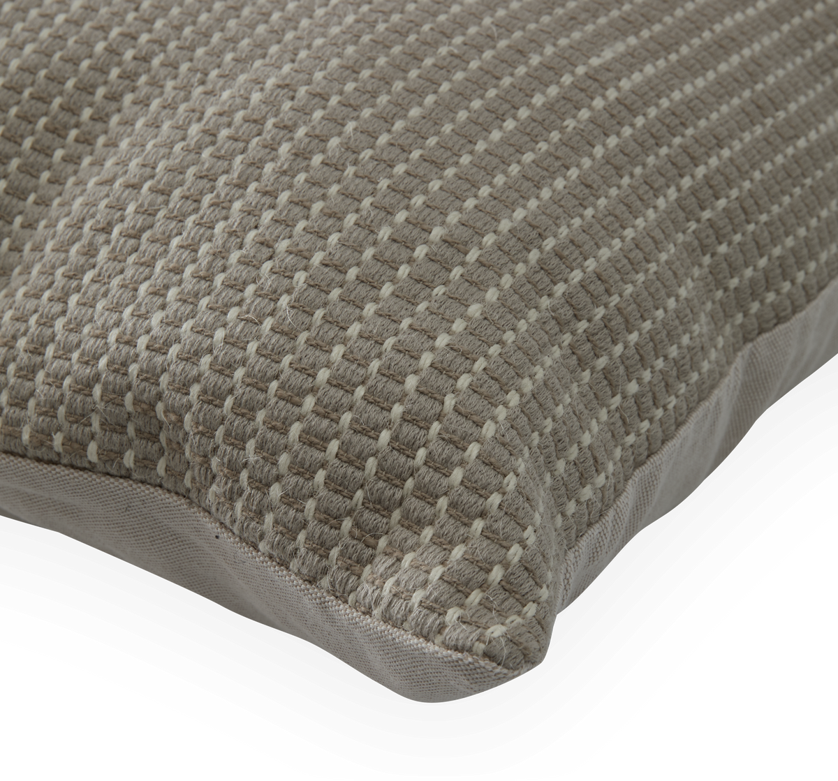 Nærbillede af beige pude med vævet, ternet struktur mod sort baggrund.