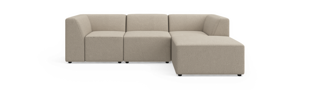Beige modulsofa i hjørneopstilling med chaiselong til højre, fotograferet lige forfra på hvid baggrund.