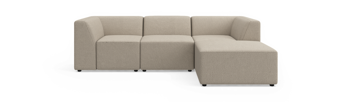 Beige modulsofa i hjørneopstilling med chaiselong til højre, fotograferet lige forfra på hvid baggrund.
