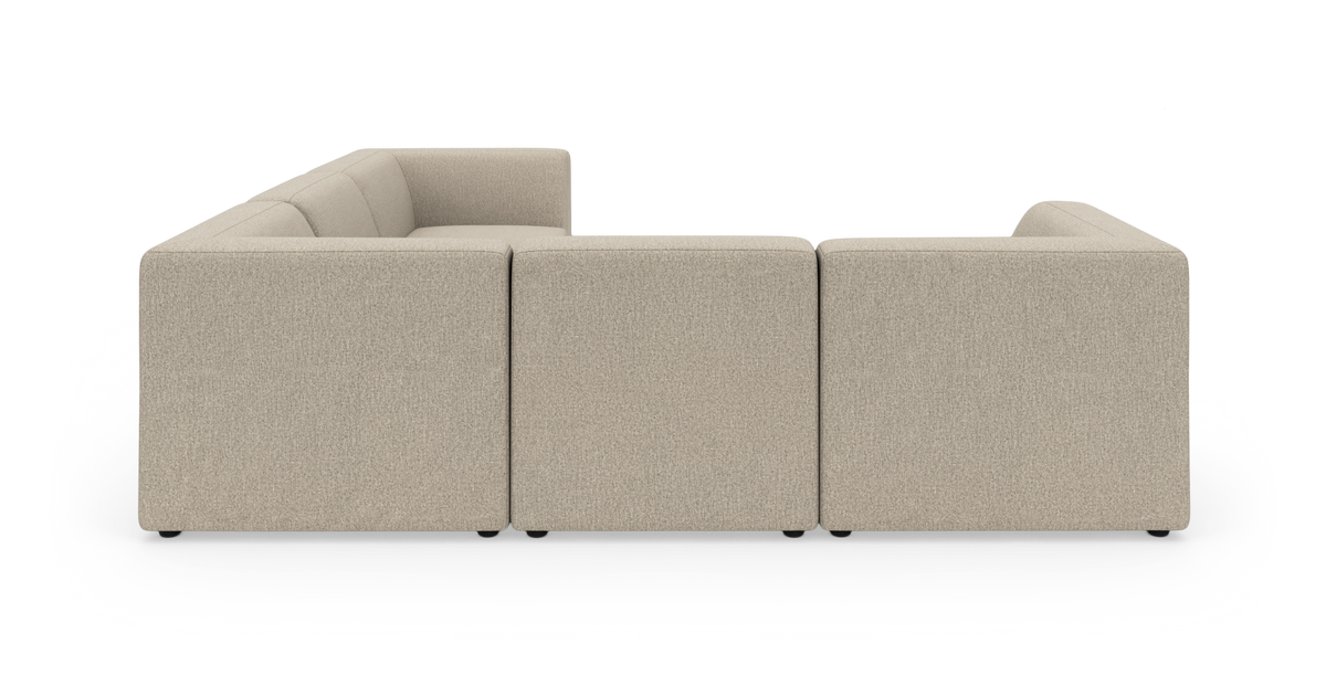Beige L‑formet modulsofa på sort baggrund.