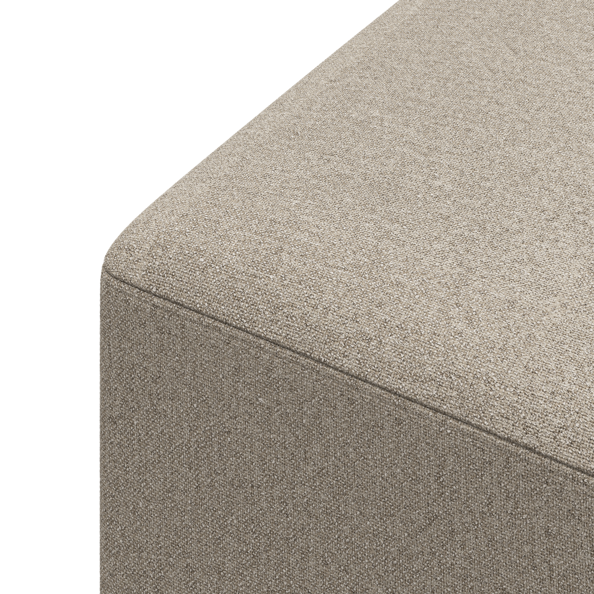 Nærbillede af hjørnet på en beige stofbetrukket sofa eller puf med afrundet kant, frilagt mod hvid baggrund.