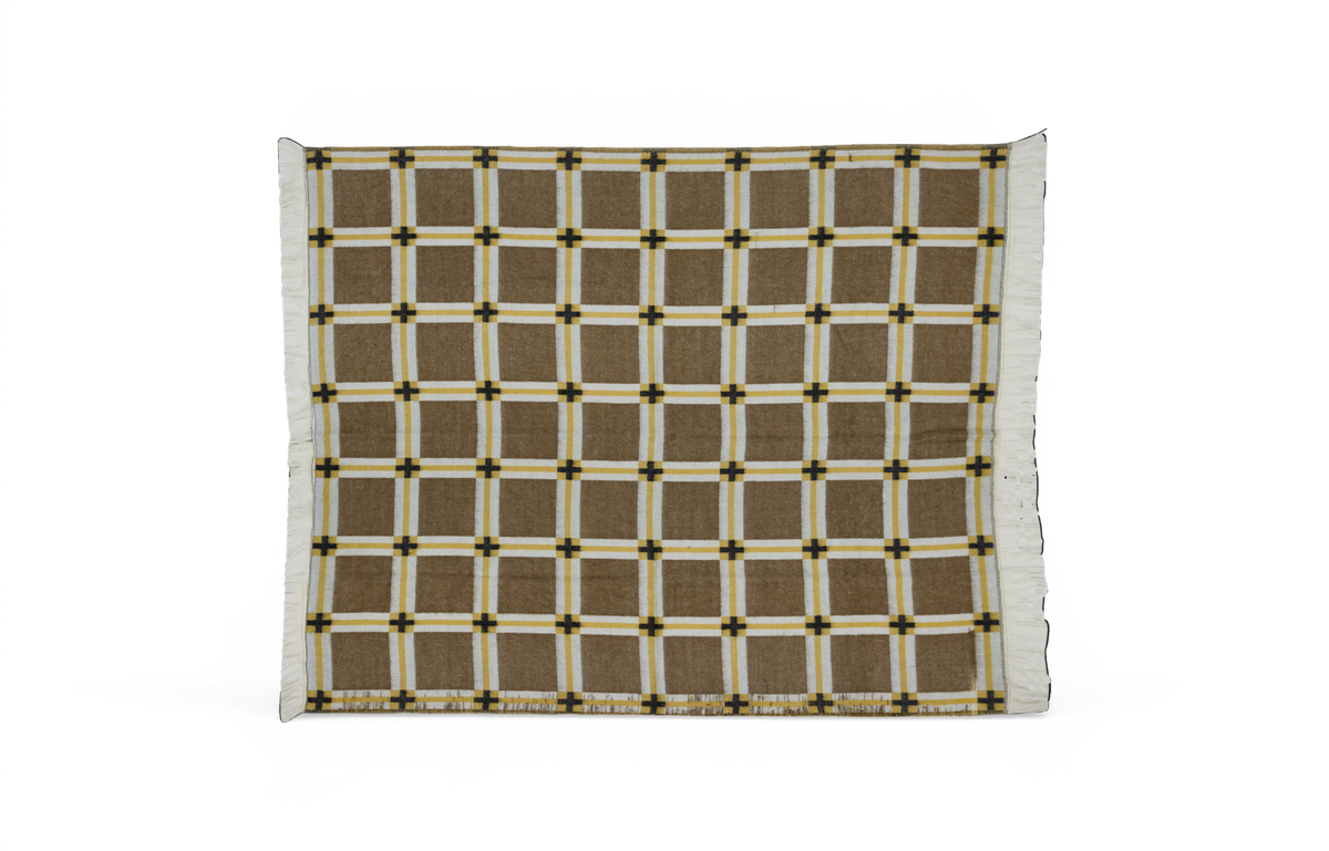 Ternet plaid i brun med hvide og gule striber og frynsekanter, fotograferet mod neutral baggrund.