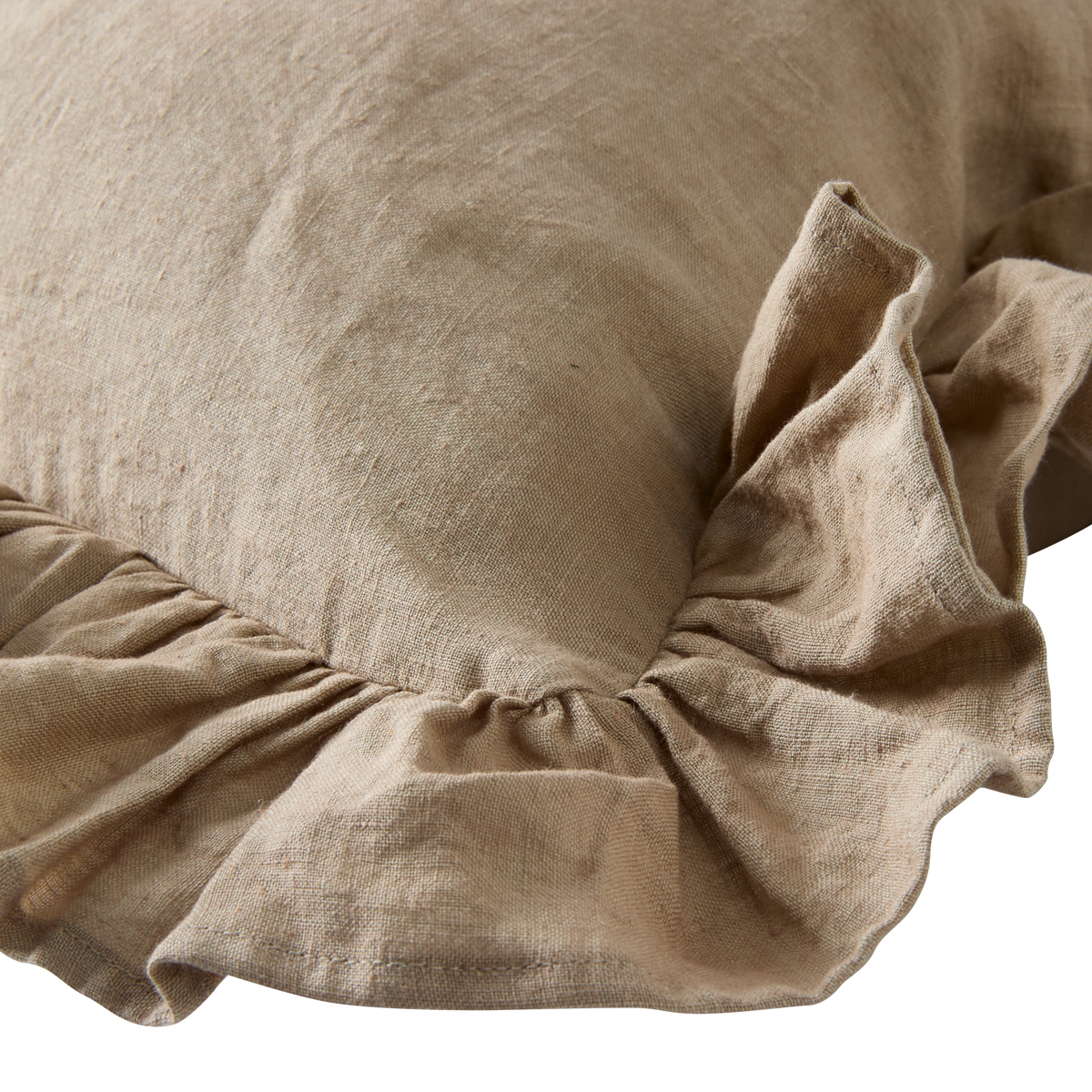 Beige hørpude med rynket flæsekant i nærbillede.