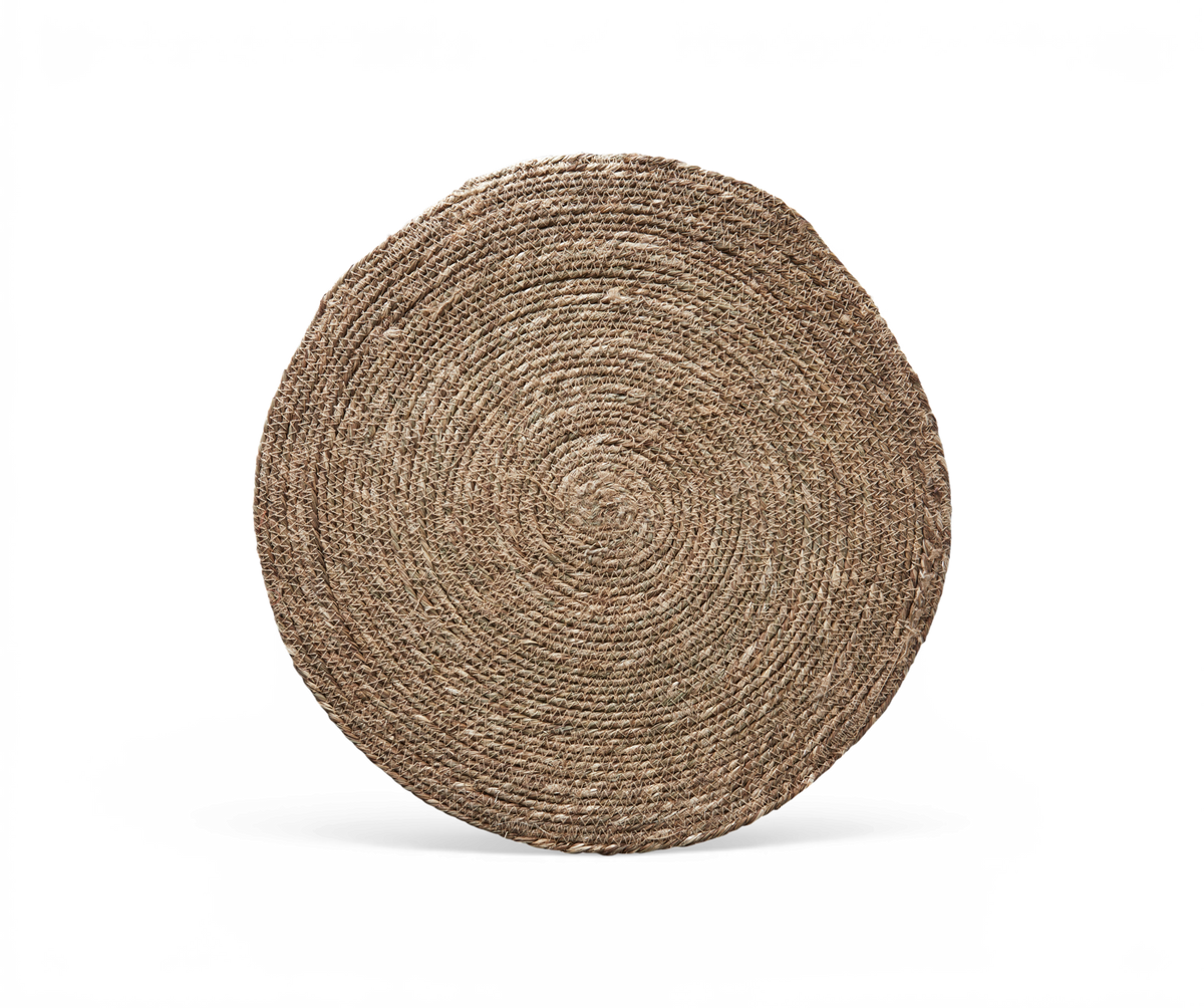 Rund jutemåtte i naturfarve med flettet spiralstruktur, frilagt på sort baggrund.