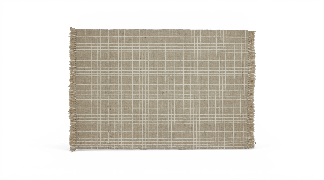 Beige tæppe med hvidt ternet mønster og frynser på kortsiderne, frilagt.